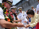 Senior US and Korean naval officers offer gifts while the carrier is in port.