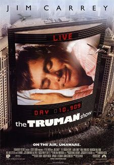 Movie poster showing a large skyscraper located next to several smaller ones. On the side of the building is a large screen, showing a man laying his head on a pillow, eyes closed and smiling. Digital text above and below the screen state "LIVE" and "DAY 10,909", with the film's title right below it. Text at the top of the image includes the sole starring credit and text at the bottom includes the film's tagline and credits.