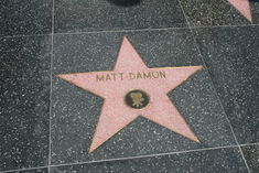 Pink granite star on a black granite side-walk.